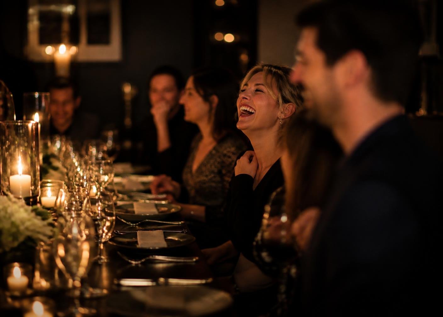Guests laughing at a private dinner