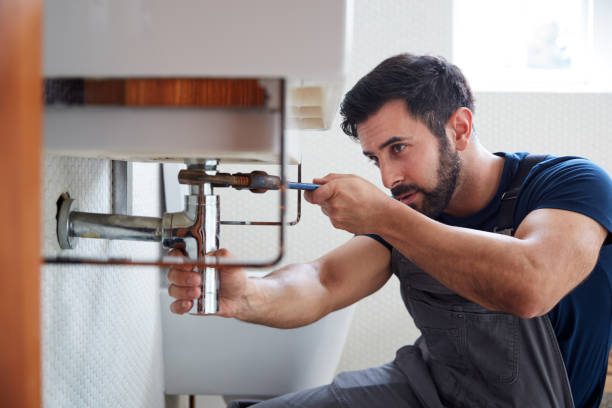 Plumber fitting new pipework beneath a bathroom basin